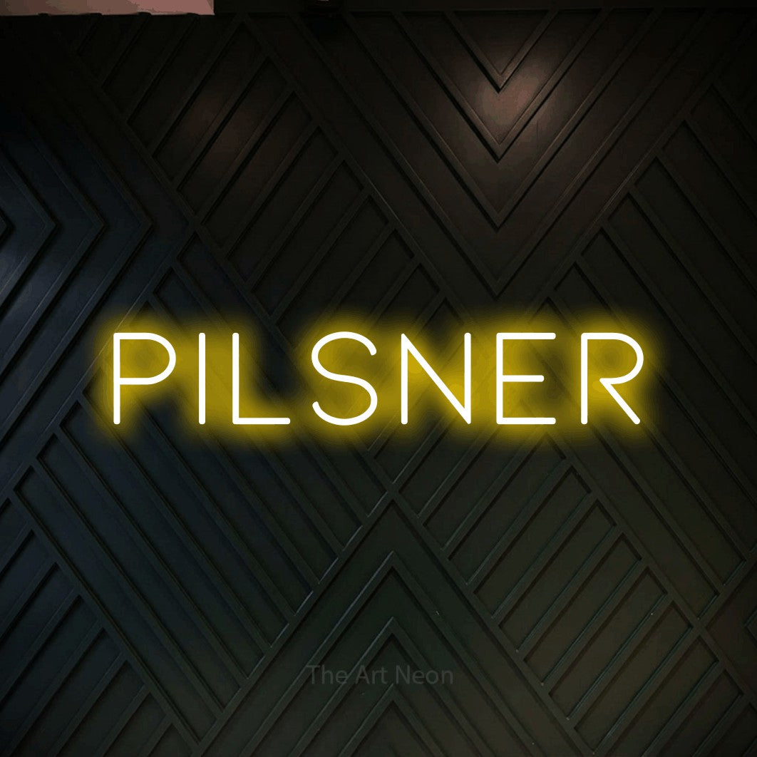 “Pilsner” LED neon sign in yellow, with thin, widely spaced lettering, shown against a black chevron-patterned wood wall.