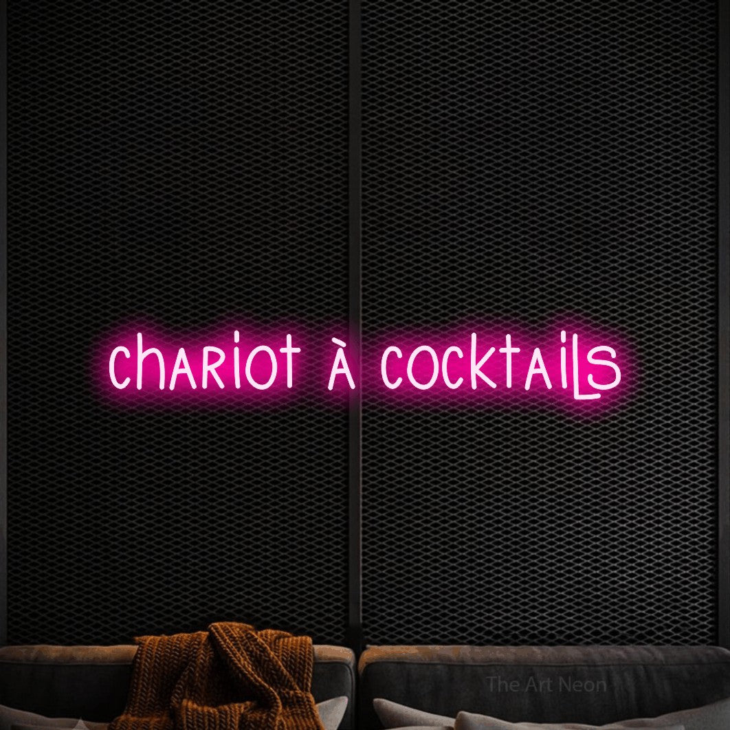 Aperçu d’une enseigne néon LED « Chariot à cocktails » en rose vif, en lettres étroites dessinées à la main, photographiée dans un coin salon moderne aux tons noirs, pour un bar à la maison.