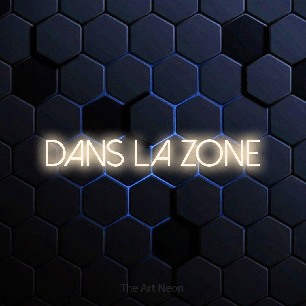 “Dans la zone” LED neon sign in warm white, with thin sans-serif lettering, shown against a dark blue honeycomb pattern.
