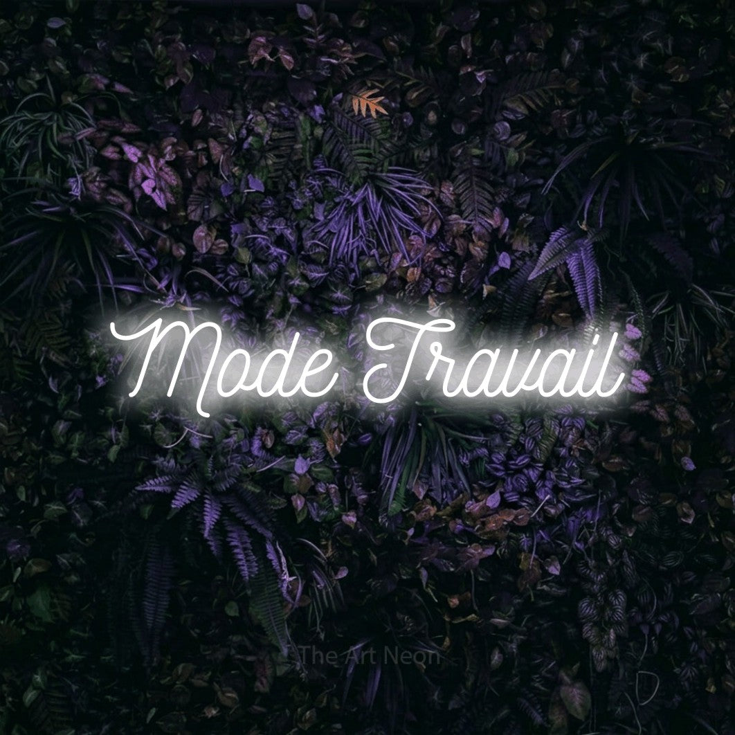 “Mode travail” LED neon sign in cool white, with ornate cursive lettering, shown against a dark wall with purple flowers.