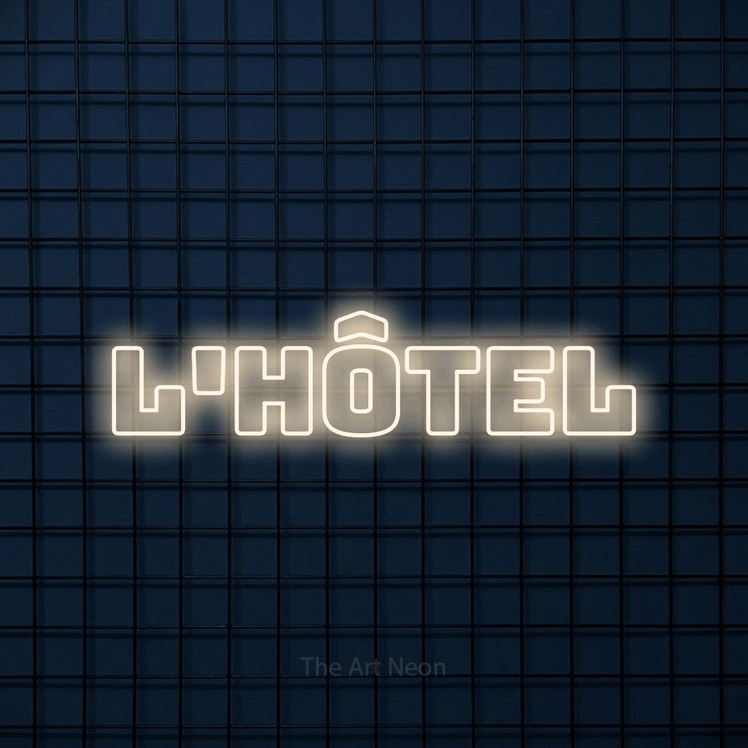 “L'hôtel” LED neon sign in warm white, with bold outline lettering, shown against a dark blue grid.