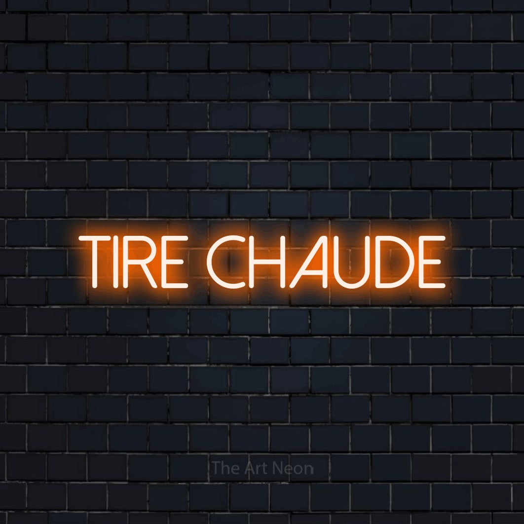 “Tire chaude” LED neon sign in orange, with thin sans-serif lettering, shown against a dark navy brick wall.