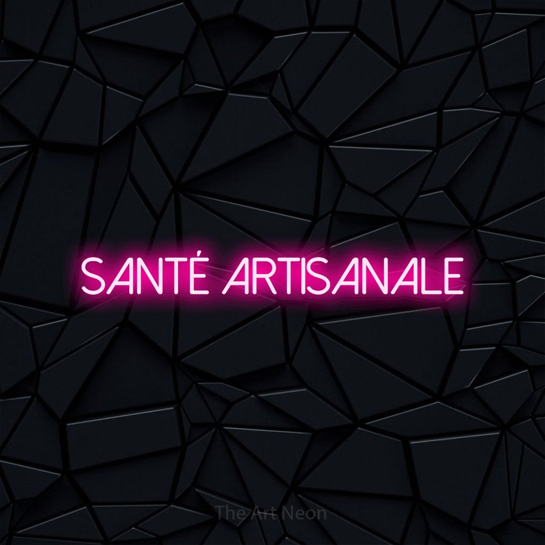 “Santé artisanale” LED neon sign in hot pink, with thin sans-serif lettering, shown against a black polygonal surface.