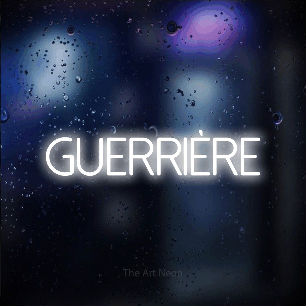 “Guerrière” LED neon sign in cool white, with thin sans-serif lettering, shown against glass with blue and purple reflections.