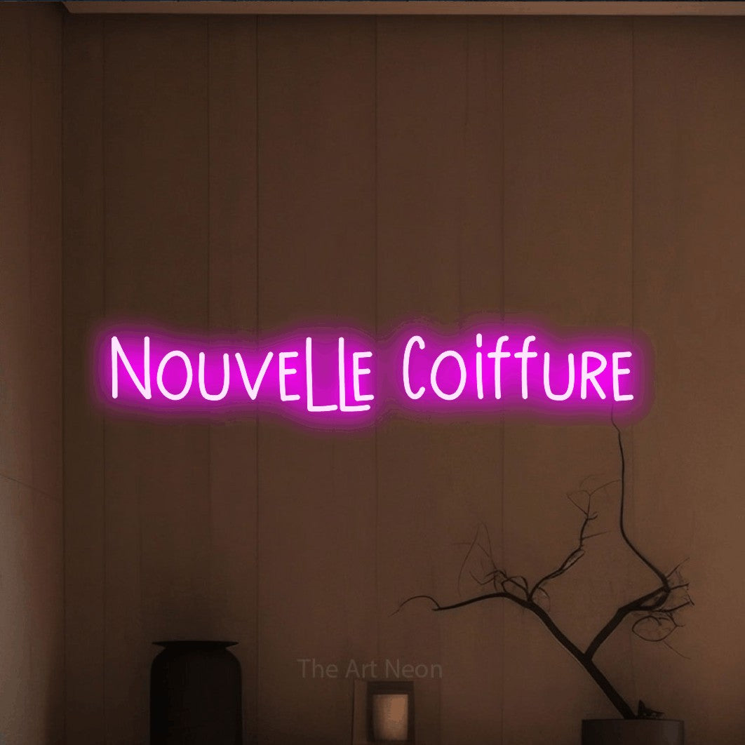 Néon LED « Nouvelle coiffure » en rose, en lettres étroites dessinées à la main, mis en scène dans un intérieur épuré aux tons terre, pour un salon de beauté.