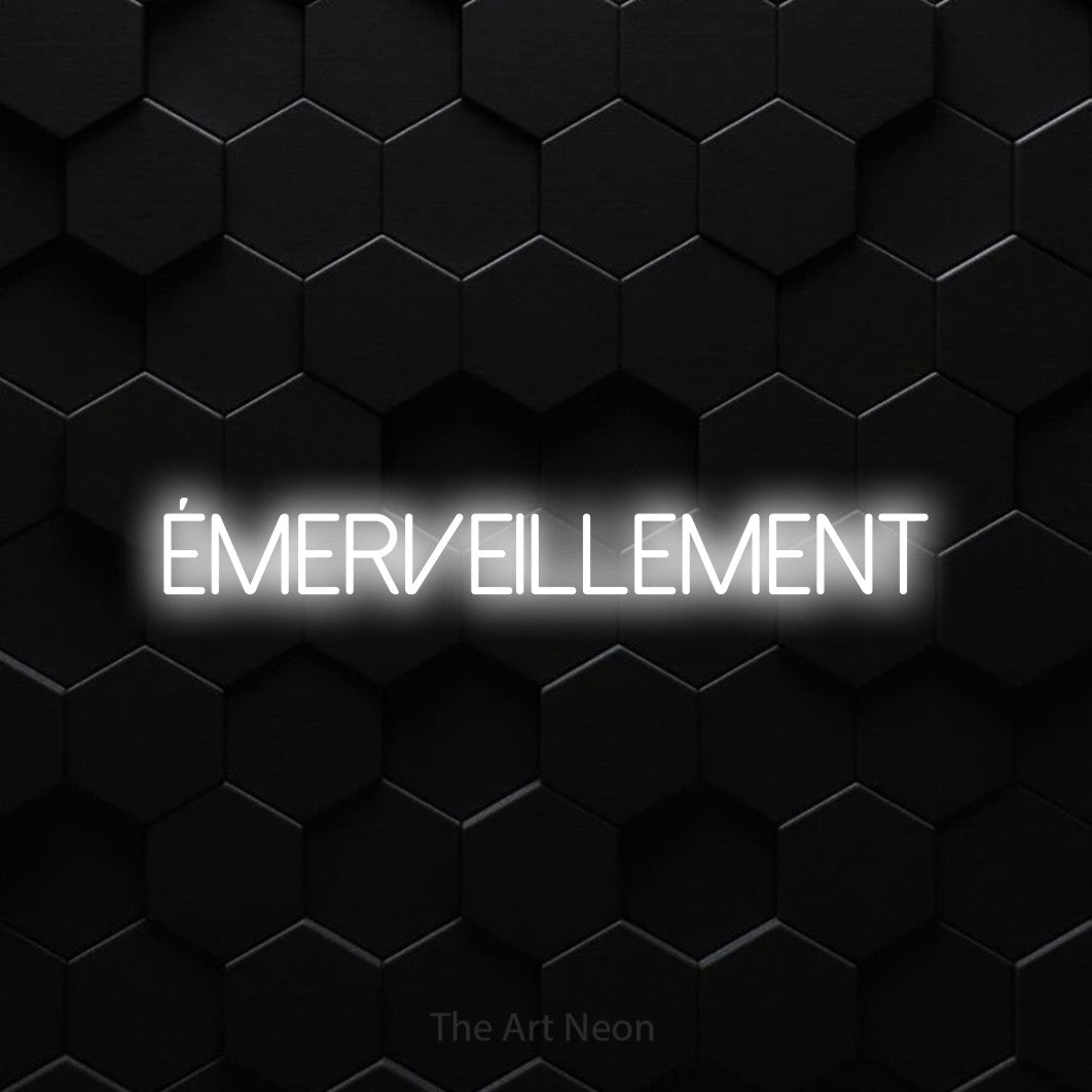“Émerveillement” LED neon sign in cool white, with thin sans-serif lettering, shown against black hexagonal wall tiles.