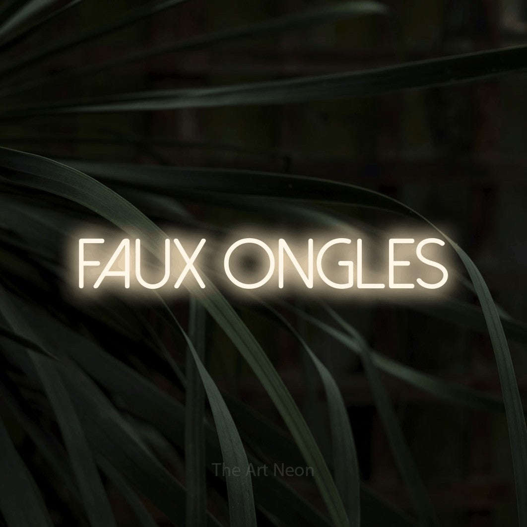 “Faux ongles” LED neon sign in warm white, with thin sans-serif lettering, shown against a close-up of dark foliage.