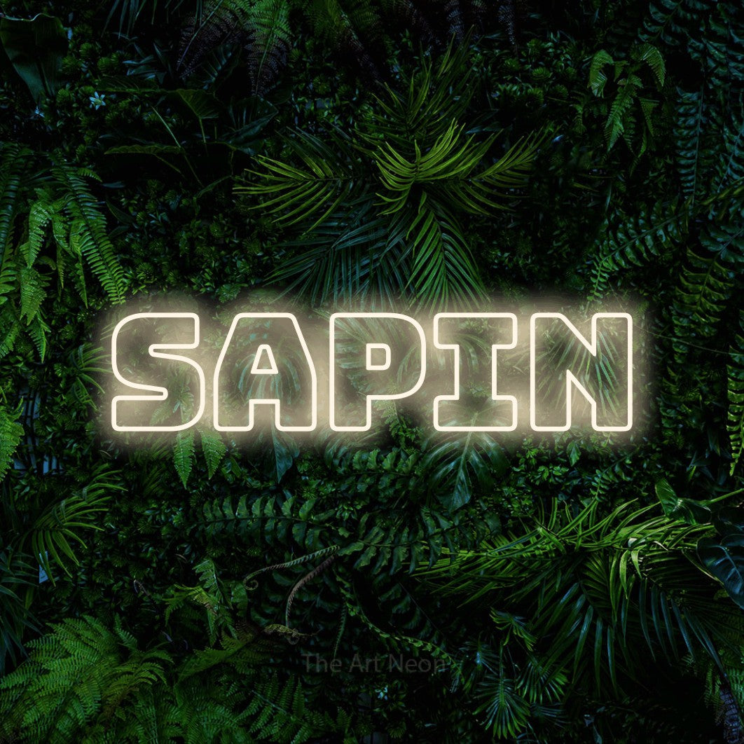 “Sapin” LED neon sign in warm white, with bold outline lettering, shown against dense tropical foliage.