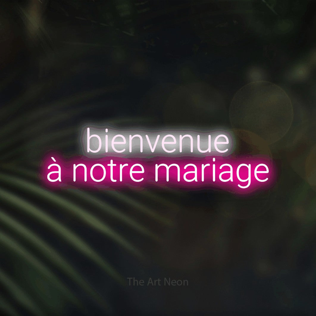 “Bienvenue à notre mariage” LED neon sign in cool white on the upper line and hot pink on the lower line, with rounded sans-serif lettering across 2 lines, shown against a blurred palm and bokeh-light backdrop.