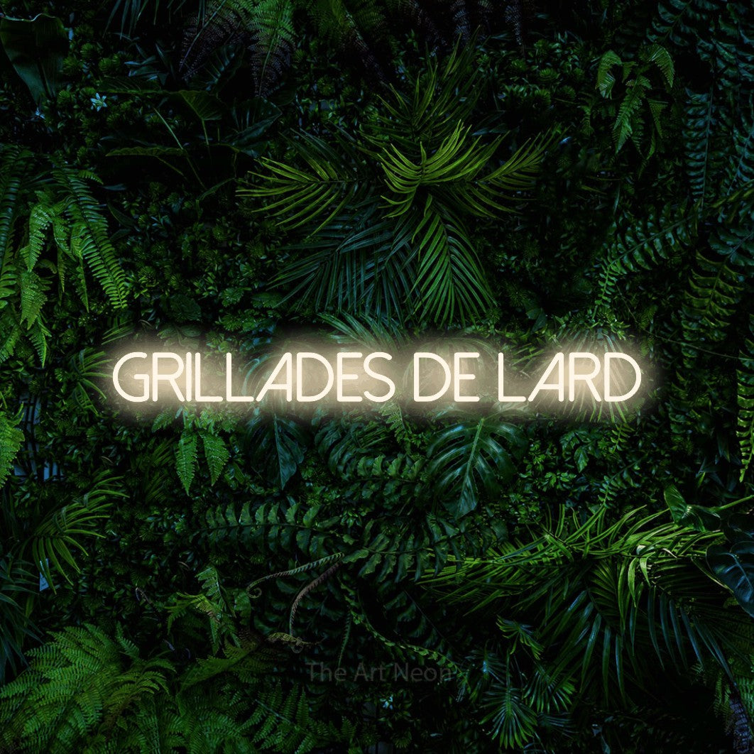 “Grillades de lard” LED neon sign in warm white, with thin sans-serif lettering, shown against dense tropical foliage.