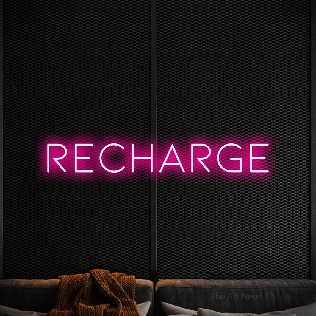 “Recharge” LED neon sign in hot pink, with thin, widely spaced lettering, shown against a modern dark-toned seating area.