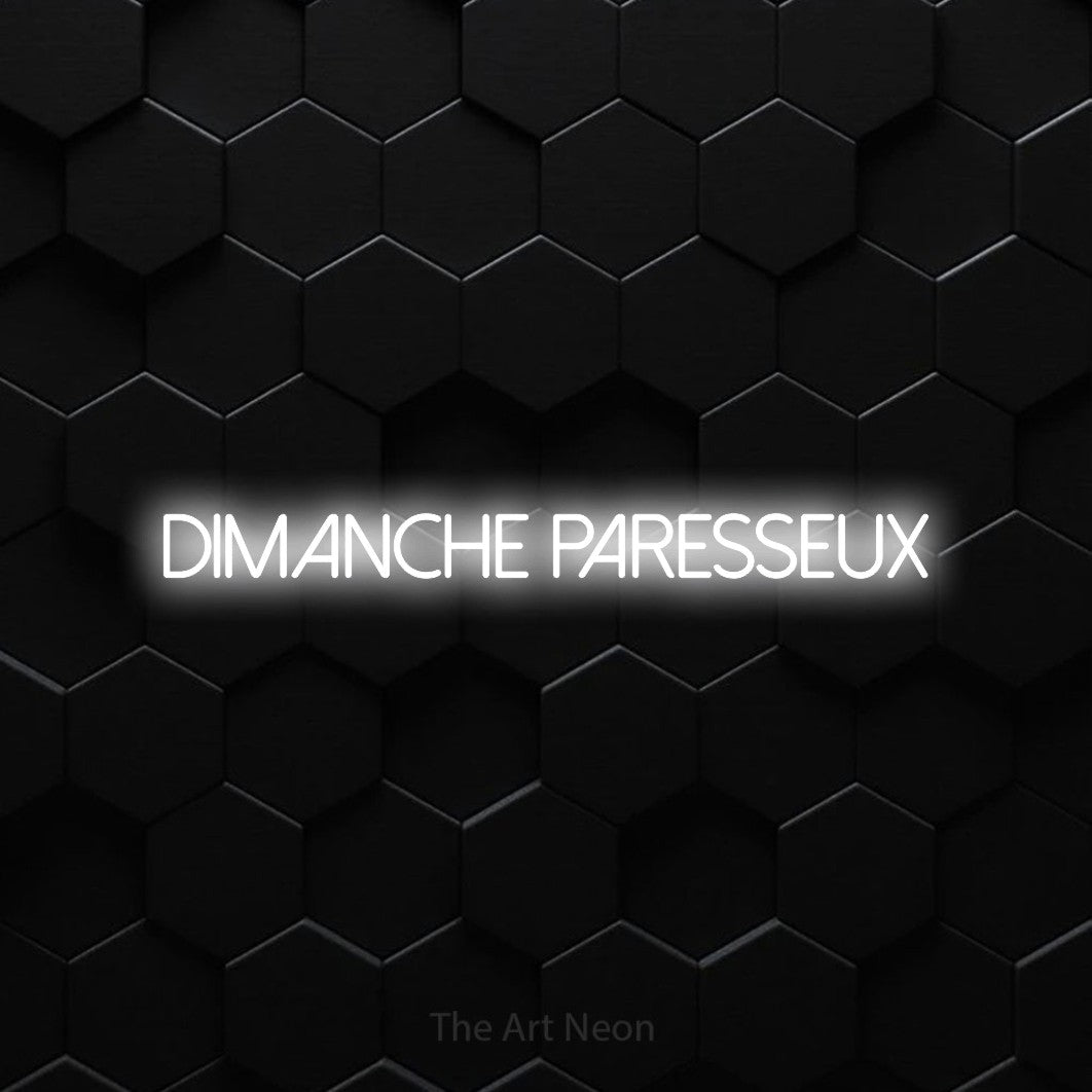 “Dimanche paresseux” LED neon sign in cool white, with thin sans-serif lettering, shown against black hexagonal wall tiles.