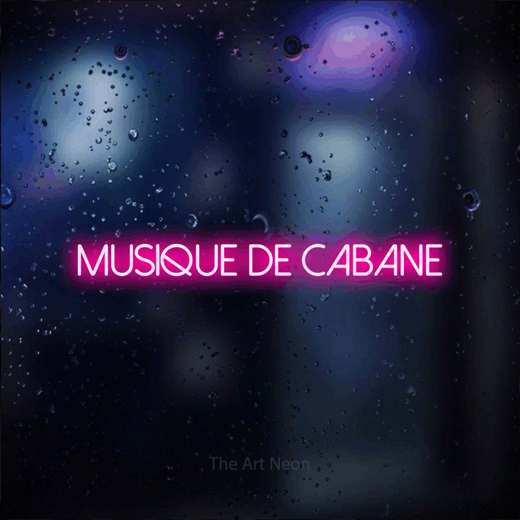 “Musique de cabane” LED neon sign in hot pink, with thin sans-serif lettering, shown against glass with blue and purple reflections.
