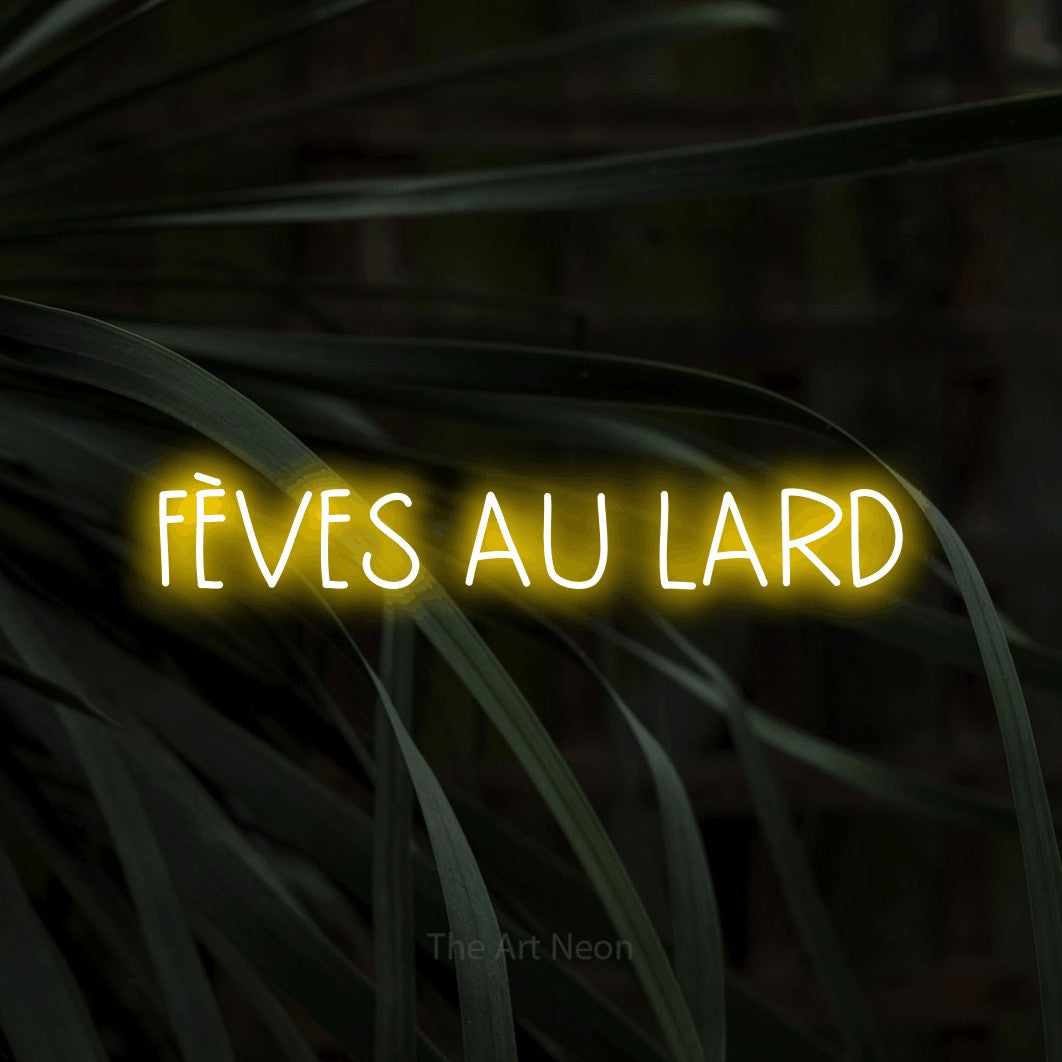 “Fèves au lard” LED neon sign in yellow, with narrow hand-drawn lettering, shown against a close-up of dark foliage.