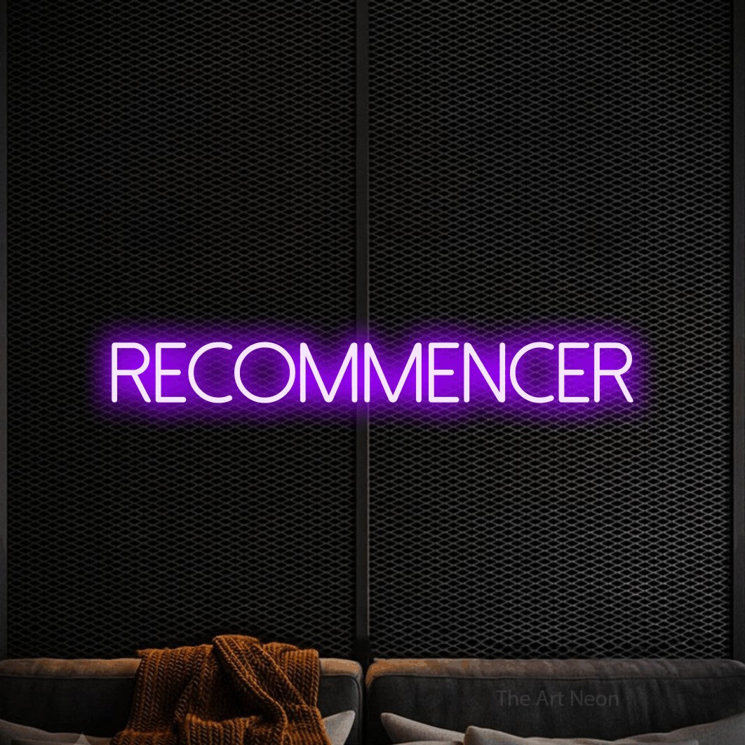 “Recommencer” LED neon sign in purple, with thin sans-serif lettering, shown against a modern dark-toned seating area.