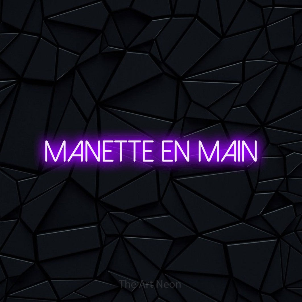 “Manette en main” LED neon sign in purple, with thin sans-serif lettering, shown against a black polygonal surface.