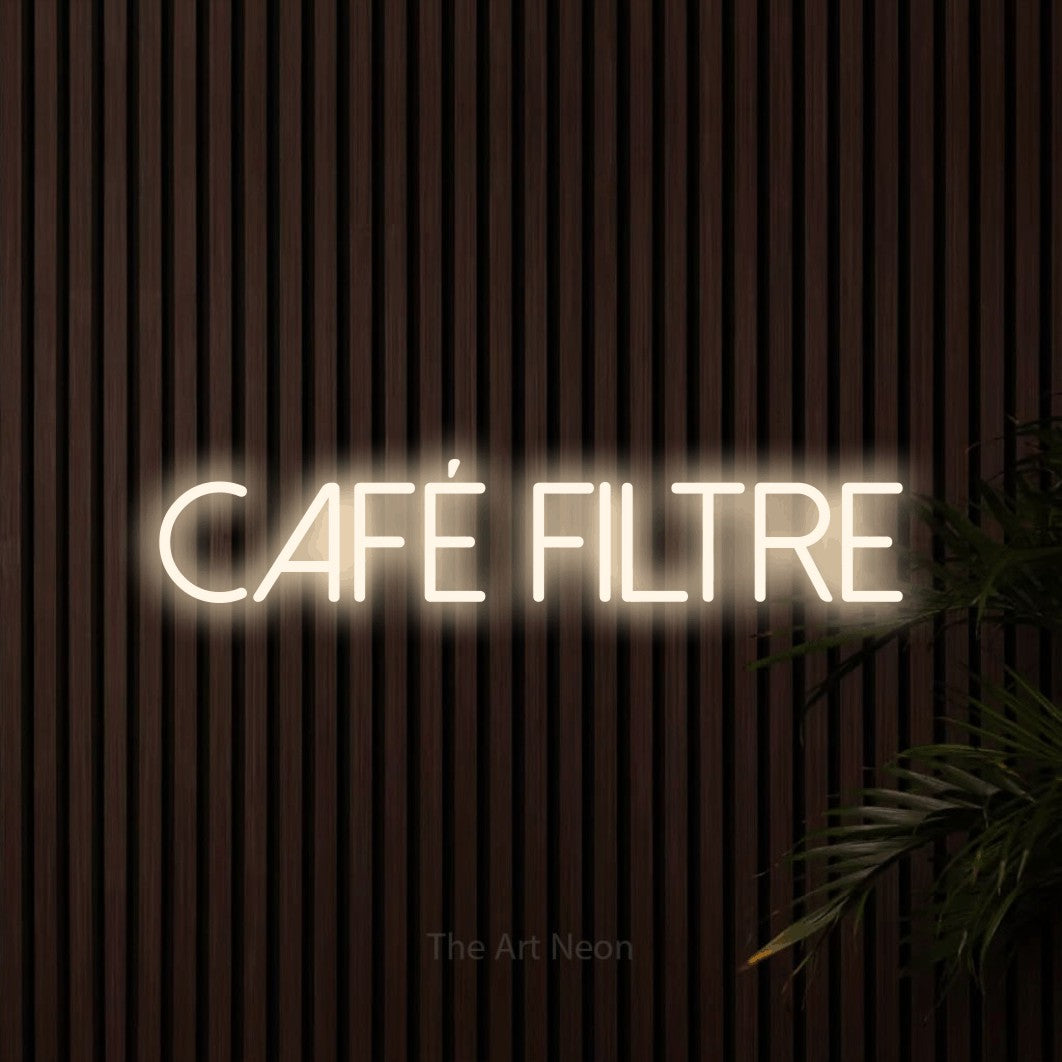Composition en néon LED « Café filtre » en blanc chaud, en lettres fines sans empattement, mise en valeur sur un mur de lattes en bois foncé, pour un café.