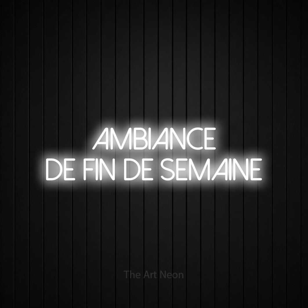 “Ambiance de fin de semaine” LED neon sign in cool white, with thin sans-serif lettering across 2 lines, shown against black vertical wall slats.