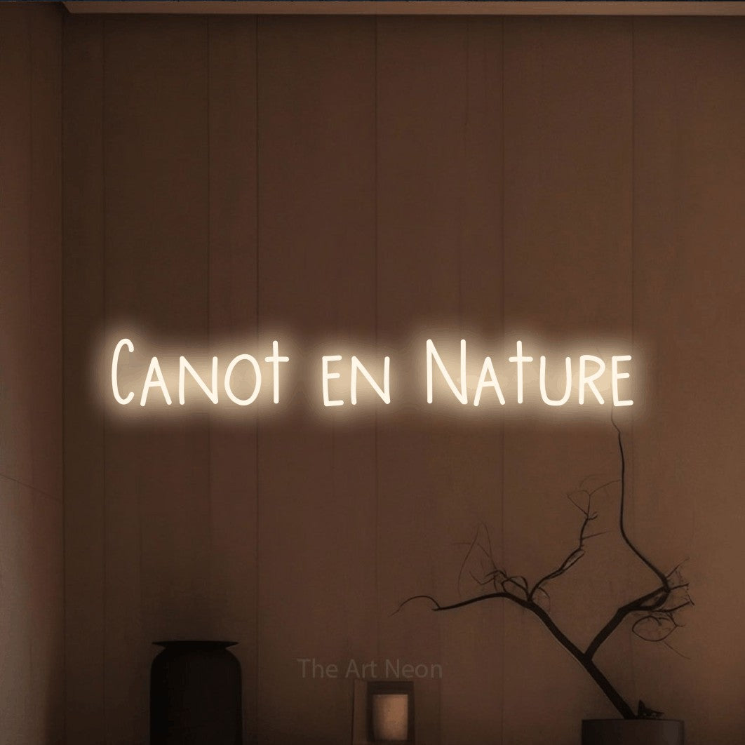 “Canot en nature” LED neon sign in warm white, with narrow hand-drawn lettering, shown against a simple earth-toned interior.