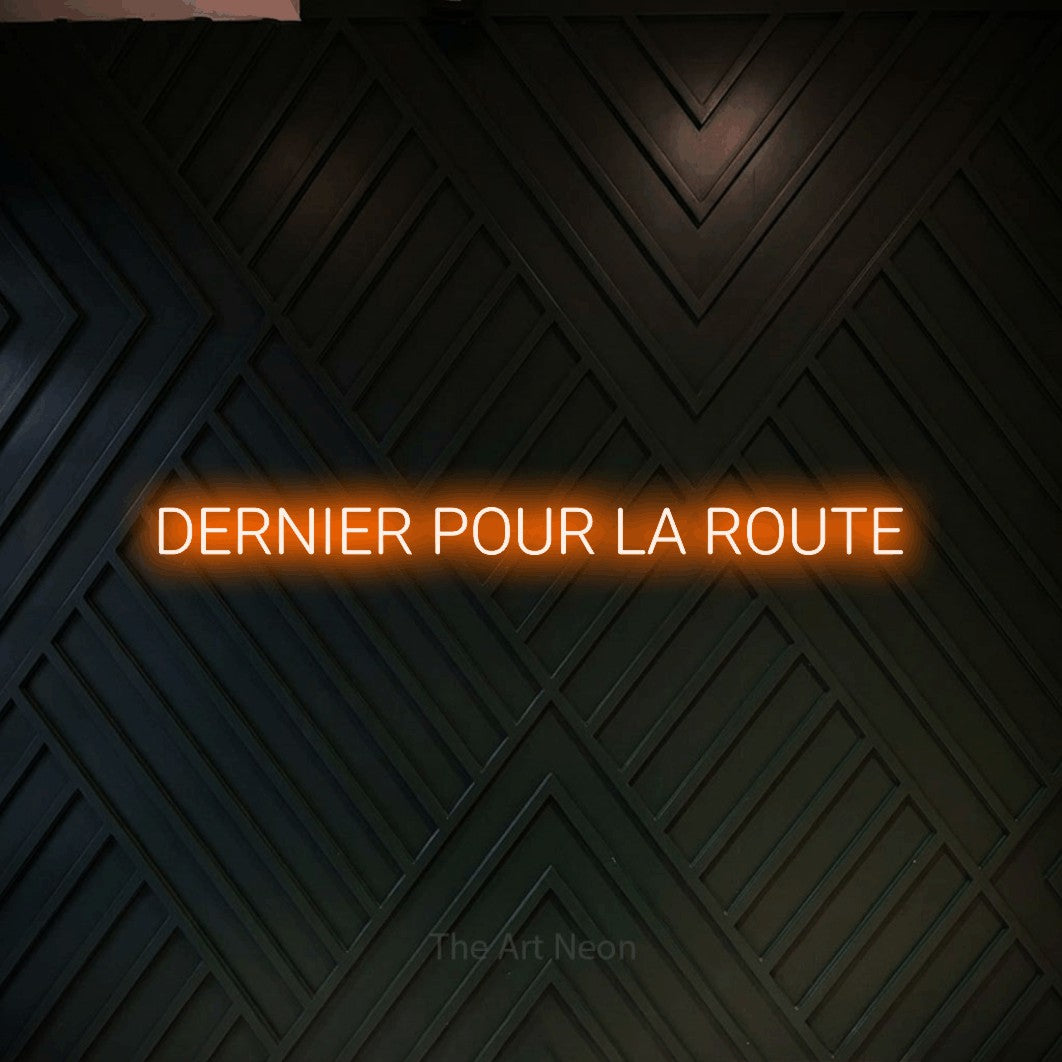 Composition en néon LED « Dernier pour la route » en orange, en lettres sans empattement arrondies, mise en valeur sur un mur en bois noir à motif chevron, pour un bar à la maison.