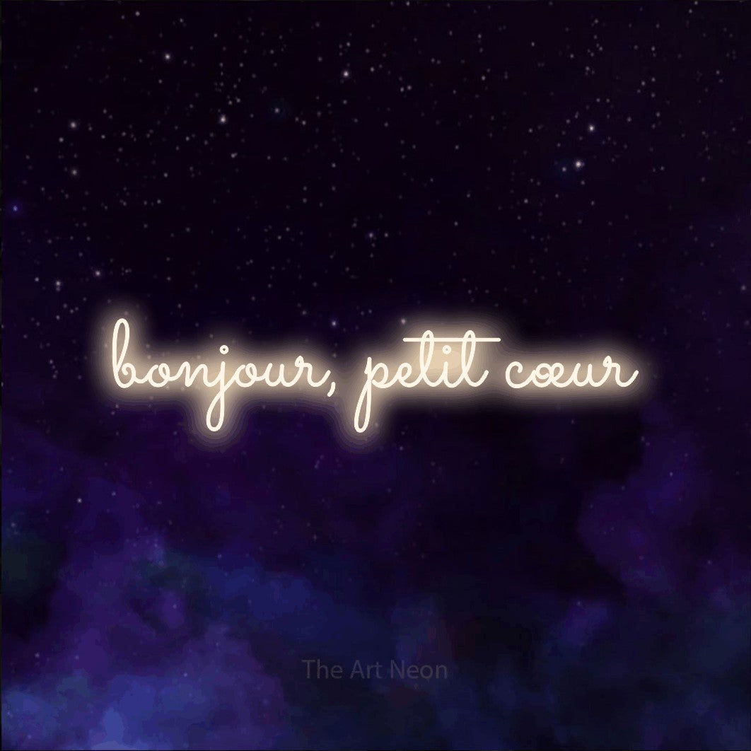 Aperçu d’une enseigne néon LED « Bonjour, petit cœur » en blanc chaud, en lettres cursives aux boucles marquées, photographiée sur une texture de galaxie violette, pour une chambre d’enfant.