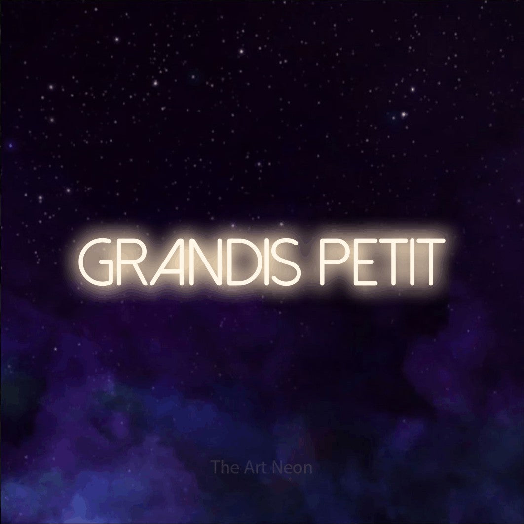 “Grandis petit” LED neon sign in warm white, with thin sans-serif lettering, shown against a purple galaxy backdrop.