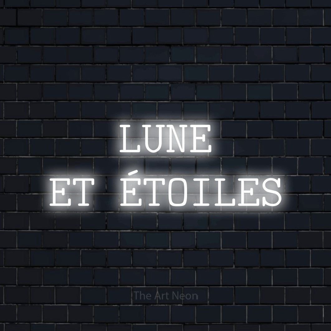 “Lune et étoiles” LED neon sign in cool white, with typewriter-style lettering across 2 lines, shown against a dark navy brick wall.