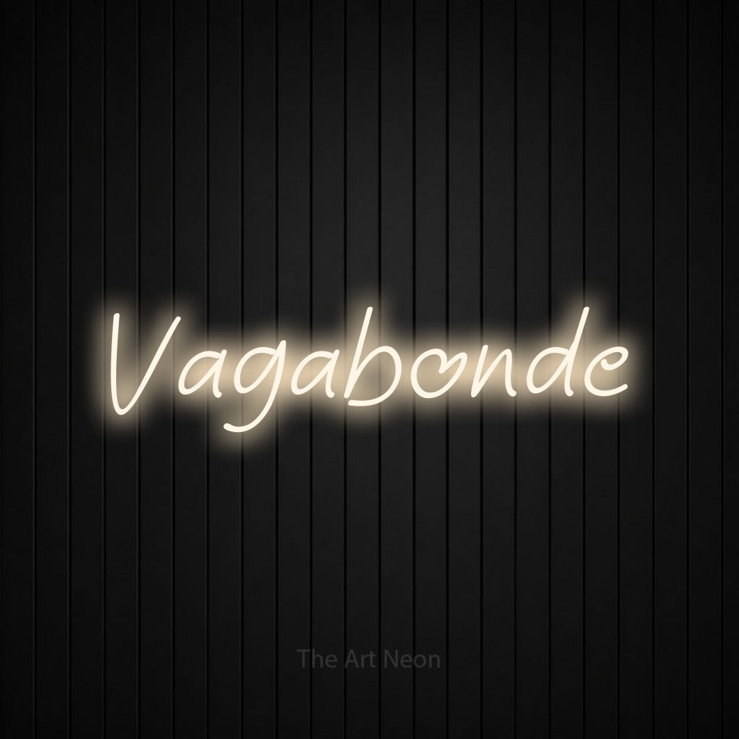 “Vagabonde” LED neon sign in warm white, with slanted handwritten lettering, shown against black vertical wall slats.