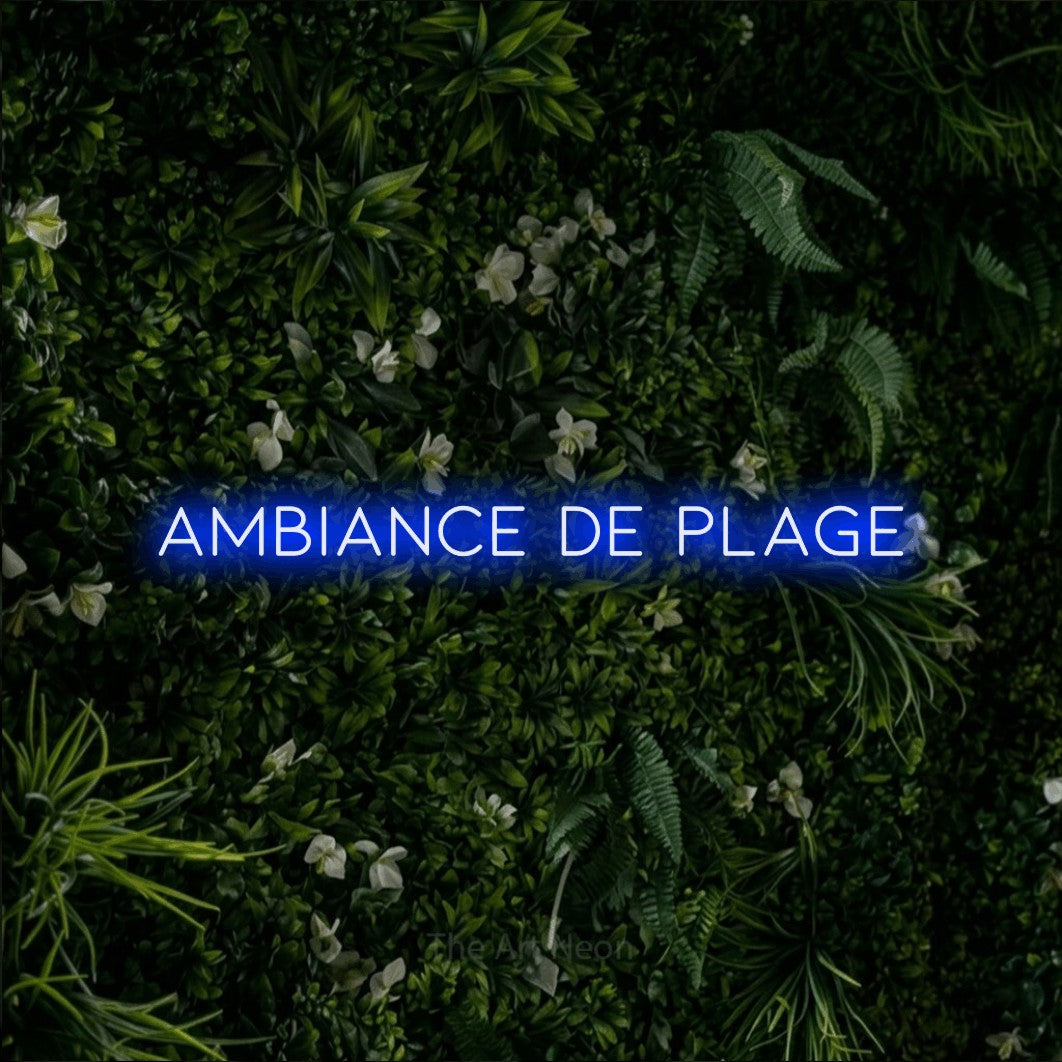 Néon LED « Ambiance de plage » en bleu, en lettres fines et espacées, mis en scène sur un mur végétal vert et dense, pour un décor inspiré de la nature.