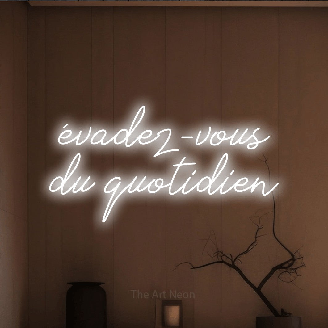 “Évadez-vous du quotidien” LED neon sign in cool white, with cursive lettering across 2 lines, shown against a simple earth-toned interior.