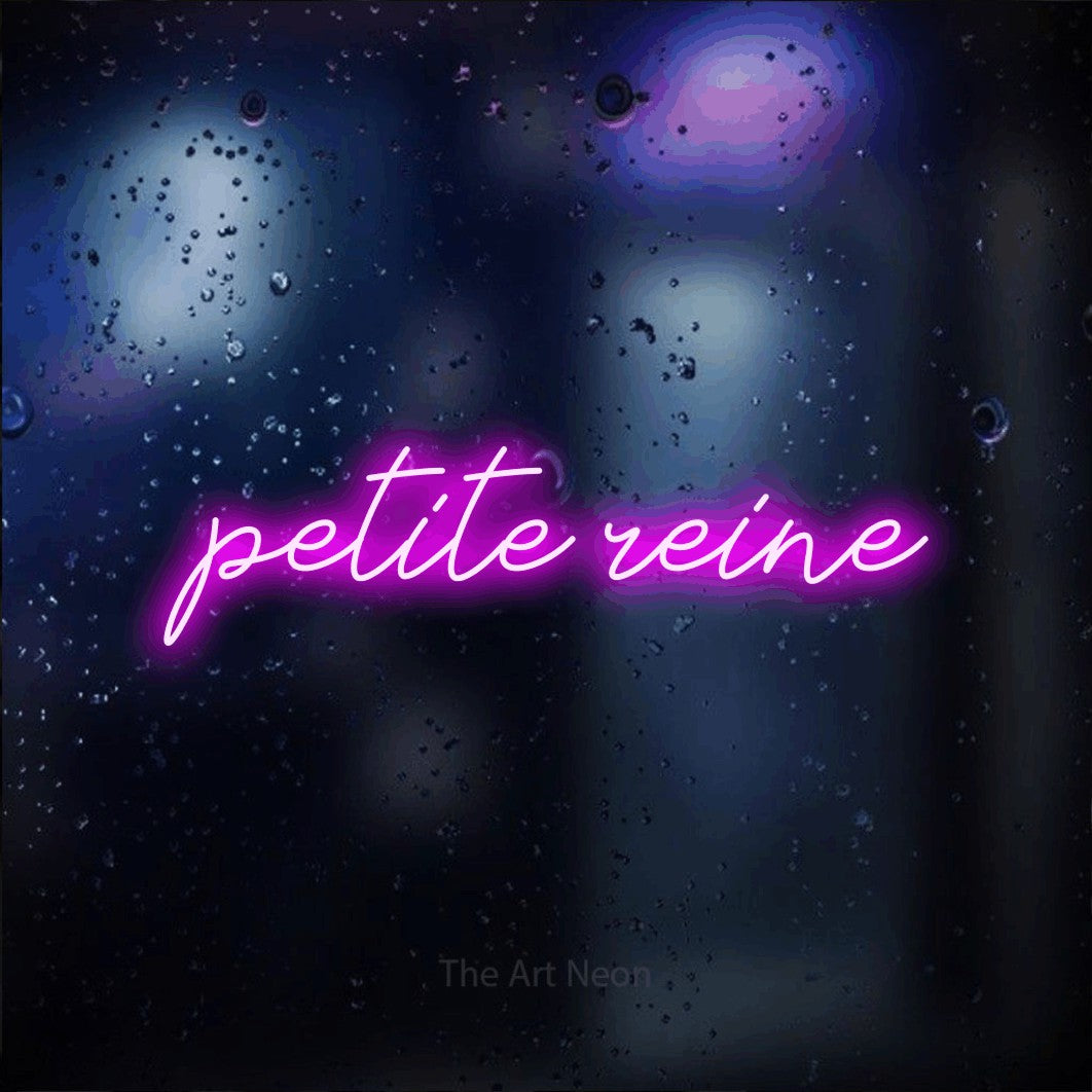 “Petite reine” LED neon sign in pink, with cursive lettering, shown against glass with blue and purple reflections.