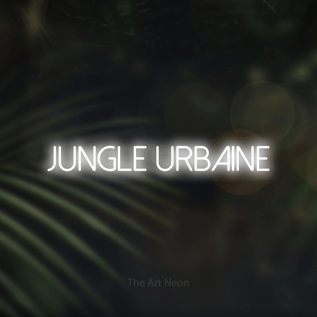 “Jungle urbaine” LED neon sign in cool white, with thin sans-serif lettering, shown against a blurred palm and bokeh-light backdrop.