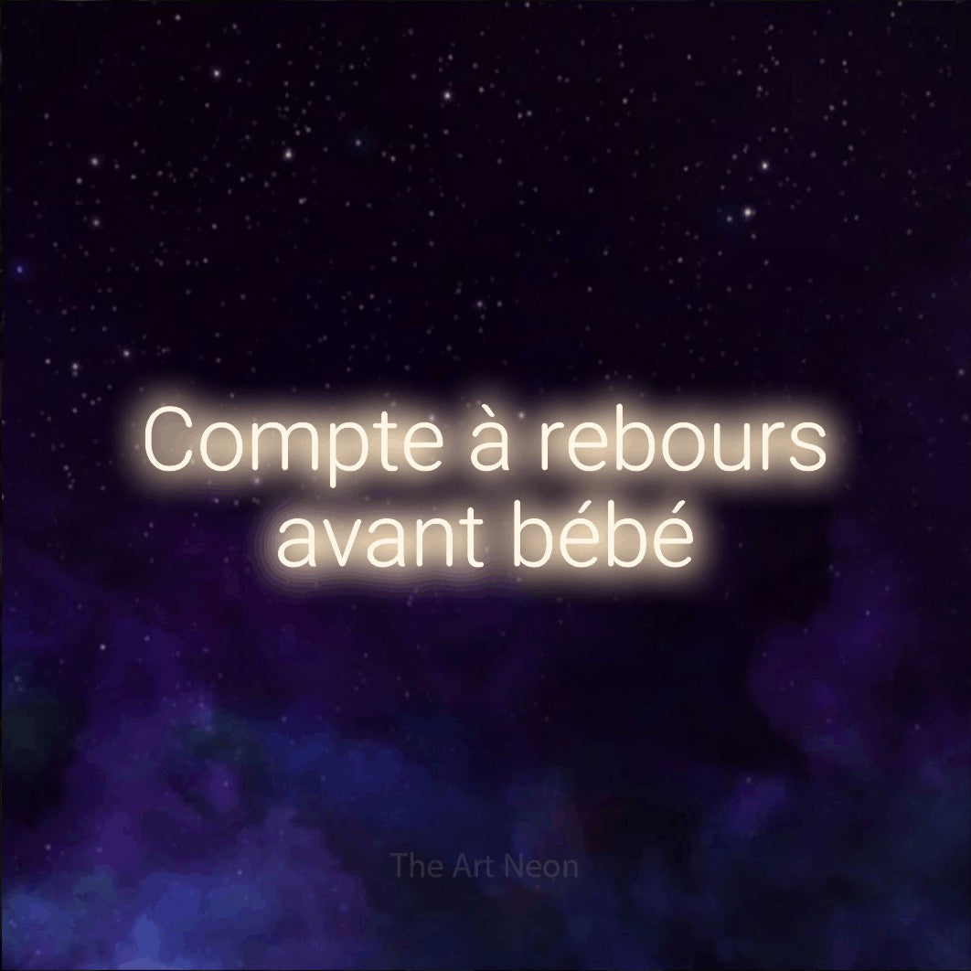 Néon LED « Compte à rebours avant bébé » sur deux lignes en blanc chaud, en lettres sans empattement arrondies, mis en scène sur une texture de galaxie violette, pour une fête prénatale.