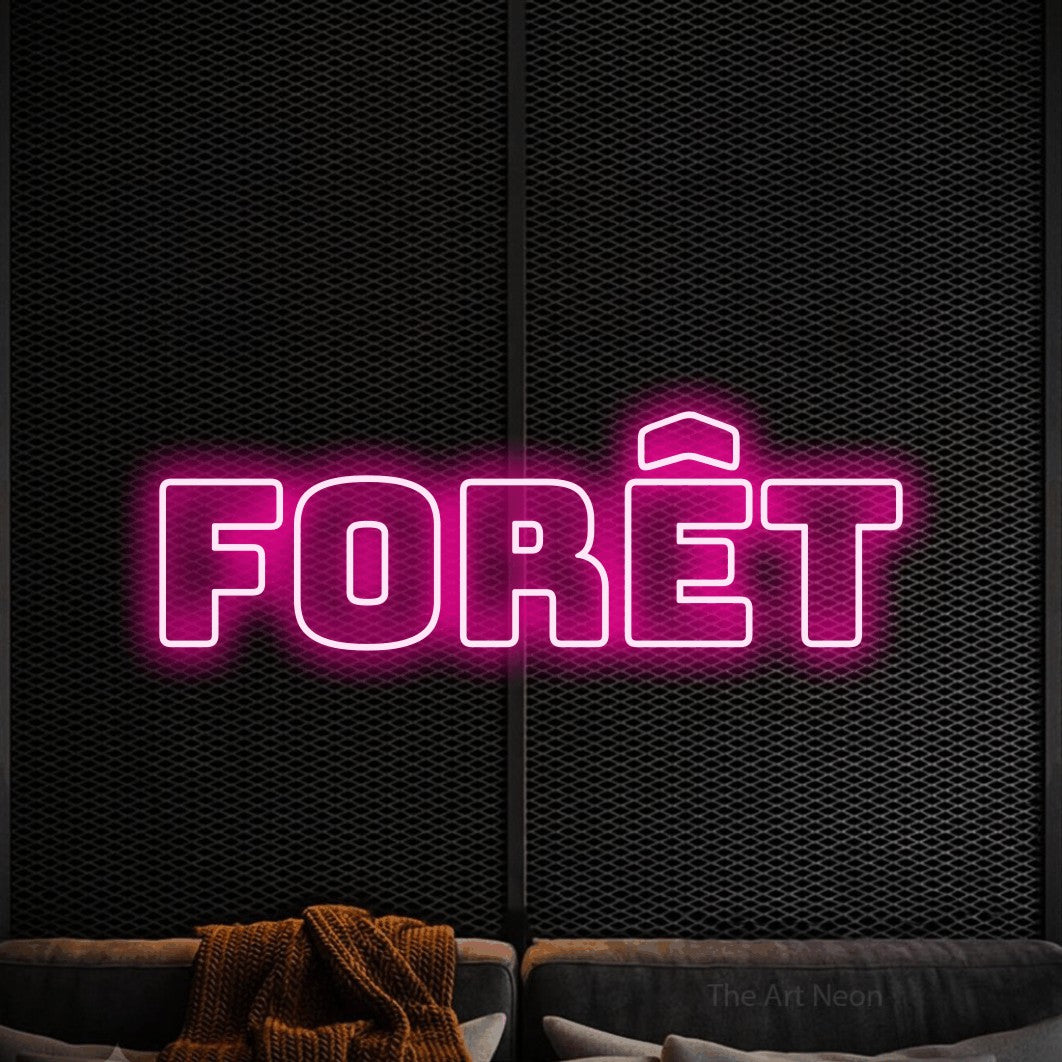 “Forêt” LED neon sign in hot pink, with bold outline lettering, shown against a modern dark-toned seating area.