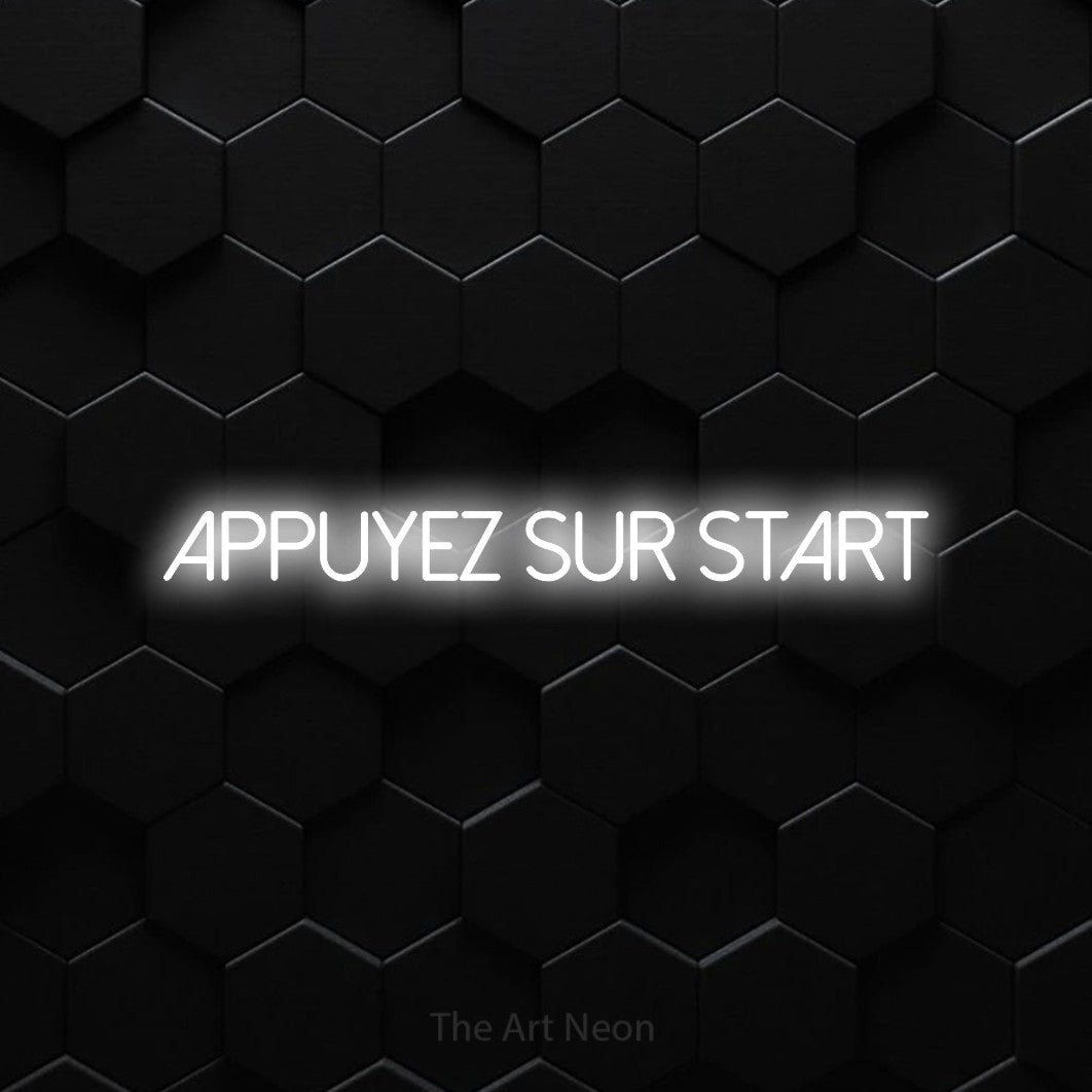 “Appuyez sur START” LED neon sign in cool white, with thin sans-serif lettering, shown against black hexagonal wall tiles.