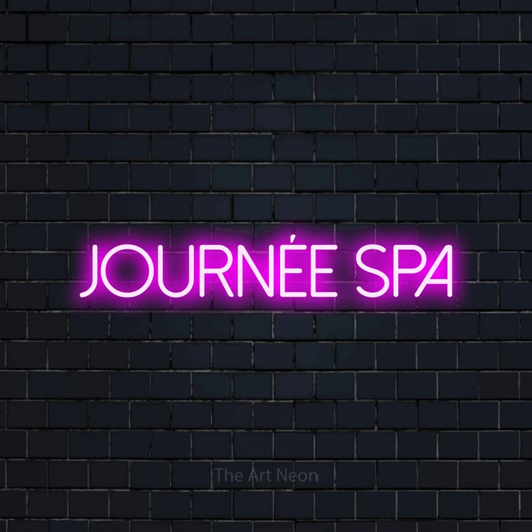 Décoration murale en néon LED « Journée spa » en rose, en lettres fines sans empattement, installée sur un mur de briques bleu marine foncé, pour un salon de beauté.