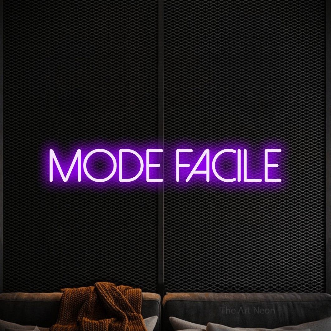 “Mode facile” LED neon sign in purple, with thin sans-serif lettering, shown against a modern dark-toned seating area.