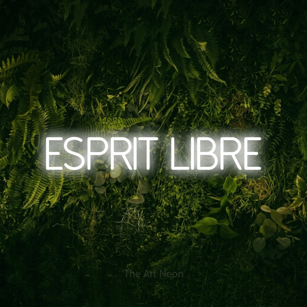 “Esprit libre” LED neon sign in cool white, with thin sans-serif lettering, shown against a dark moss and forest backdrop.