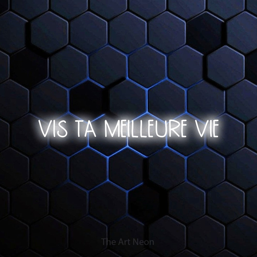 “Vis ta meilleure vie” LED neon sign in cool white, with narrow hand-drawn lettering, shown against a dark blue honeycomb pattern.