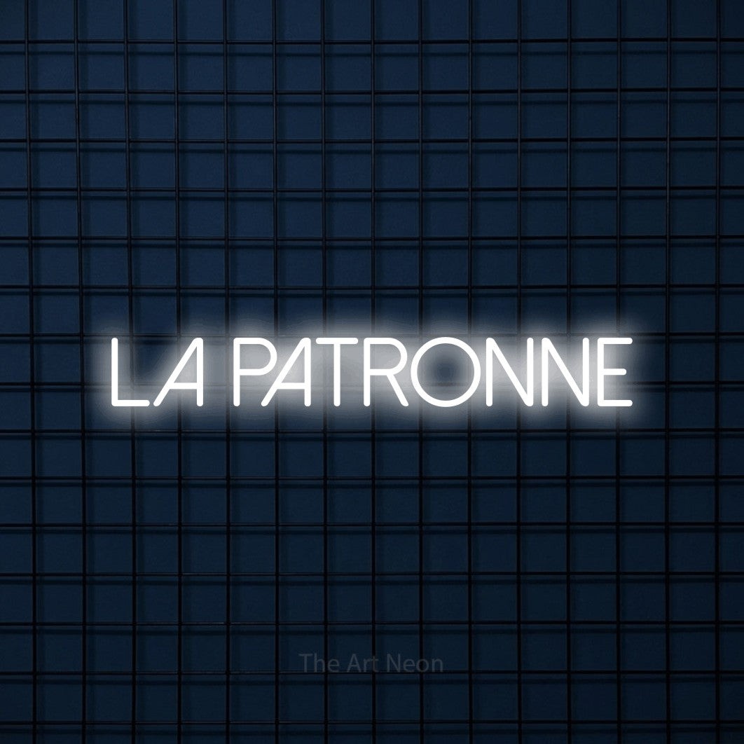 “La patronne” LED neon sign in cool white, with thin sans-serif lettering, shown against a dark blue grid.
