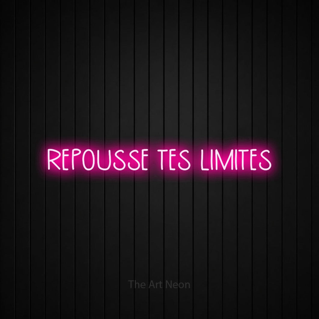 Décoration murale en néon LED « Repousse tes limites » en rose vif, en lettres étroites dessinées à la main, installée sur un mur de lattes verticales noires, pour un espace d’entraînement.