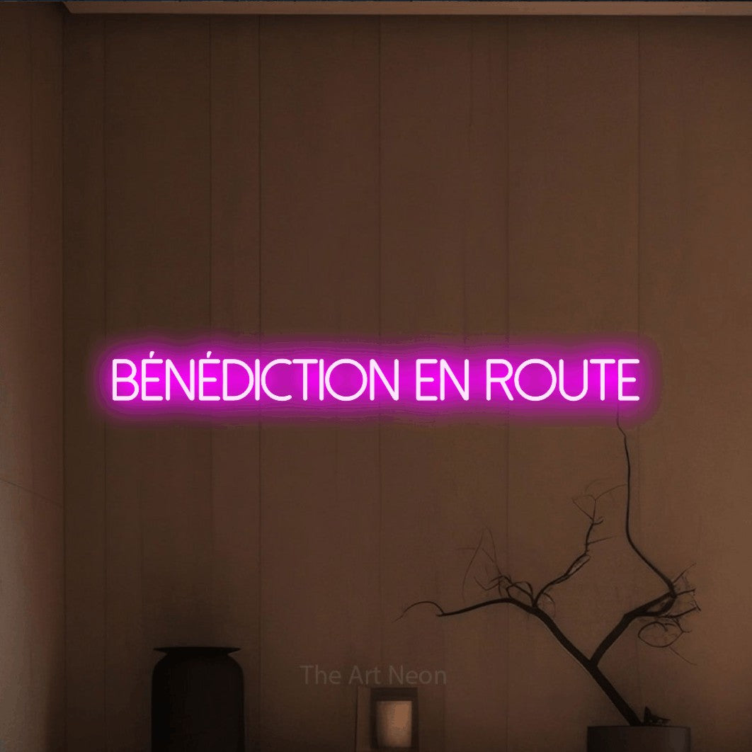 Aperçu d’une enseigne néon LED « Bénédiction en route » en rose, en lettres fines sans empattement, photographiée dans un intérieur épuré aux tons terre, pour une fête prénatale.