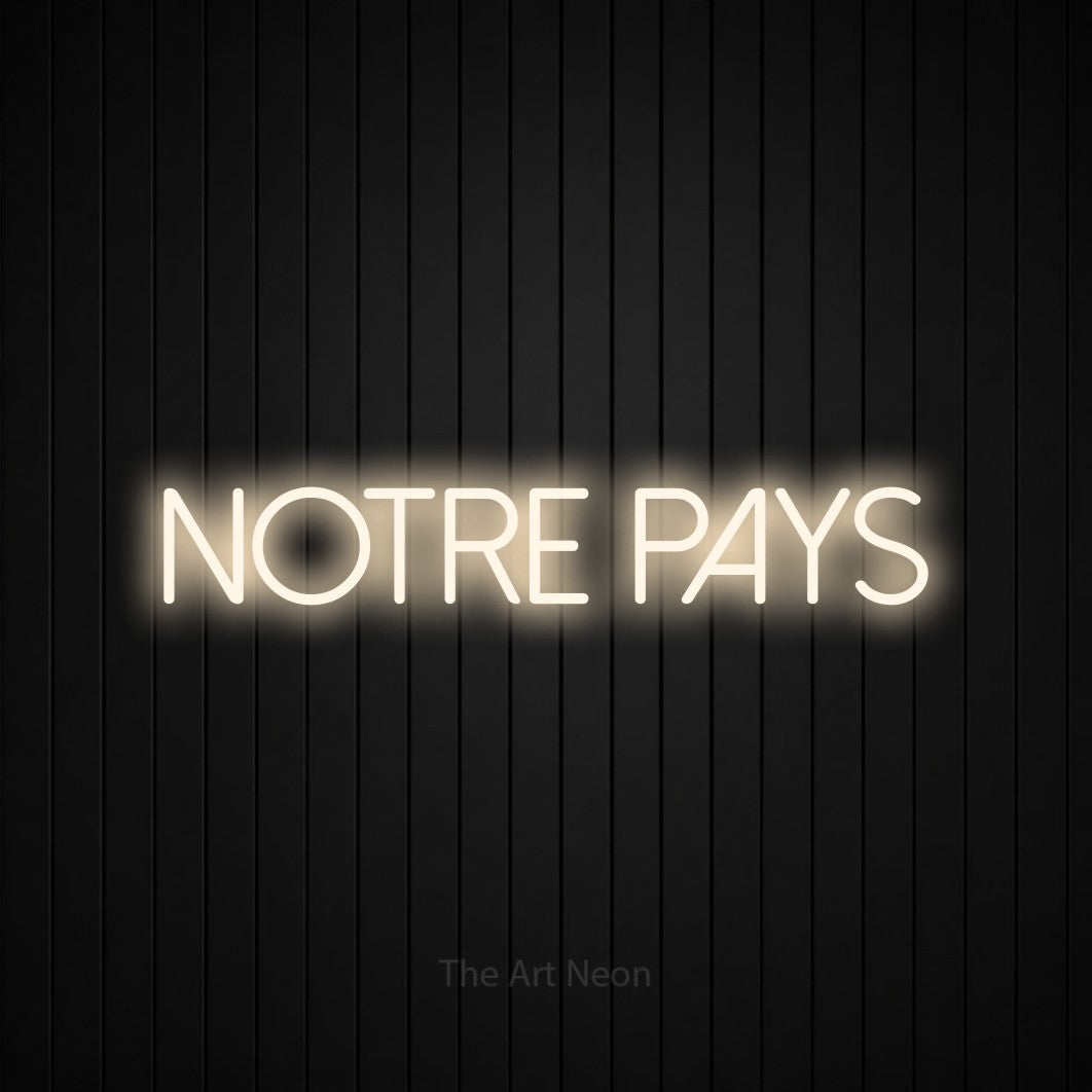 “Notre pays” LED neon sign in warm white, with thin sans-serif lettering, shown against black vertical wall slats.