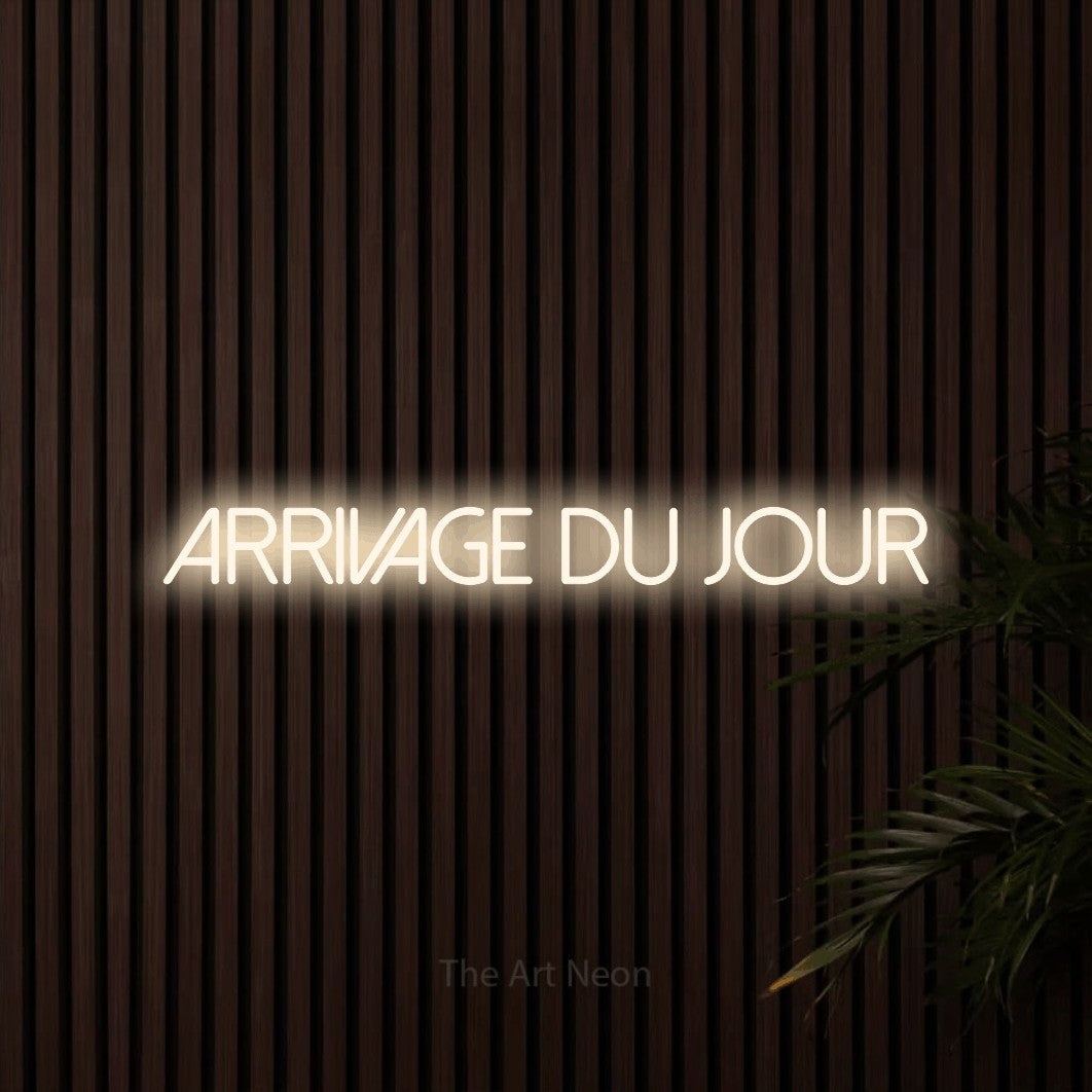 “Arrivage du jour” LED neon sign in warm white, with thin sans-serif lettering, shown against dark wooden wall slats.