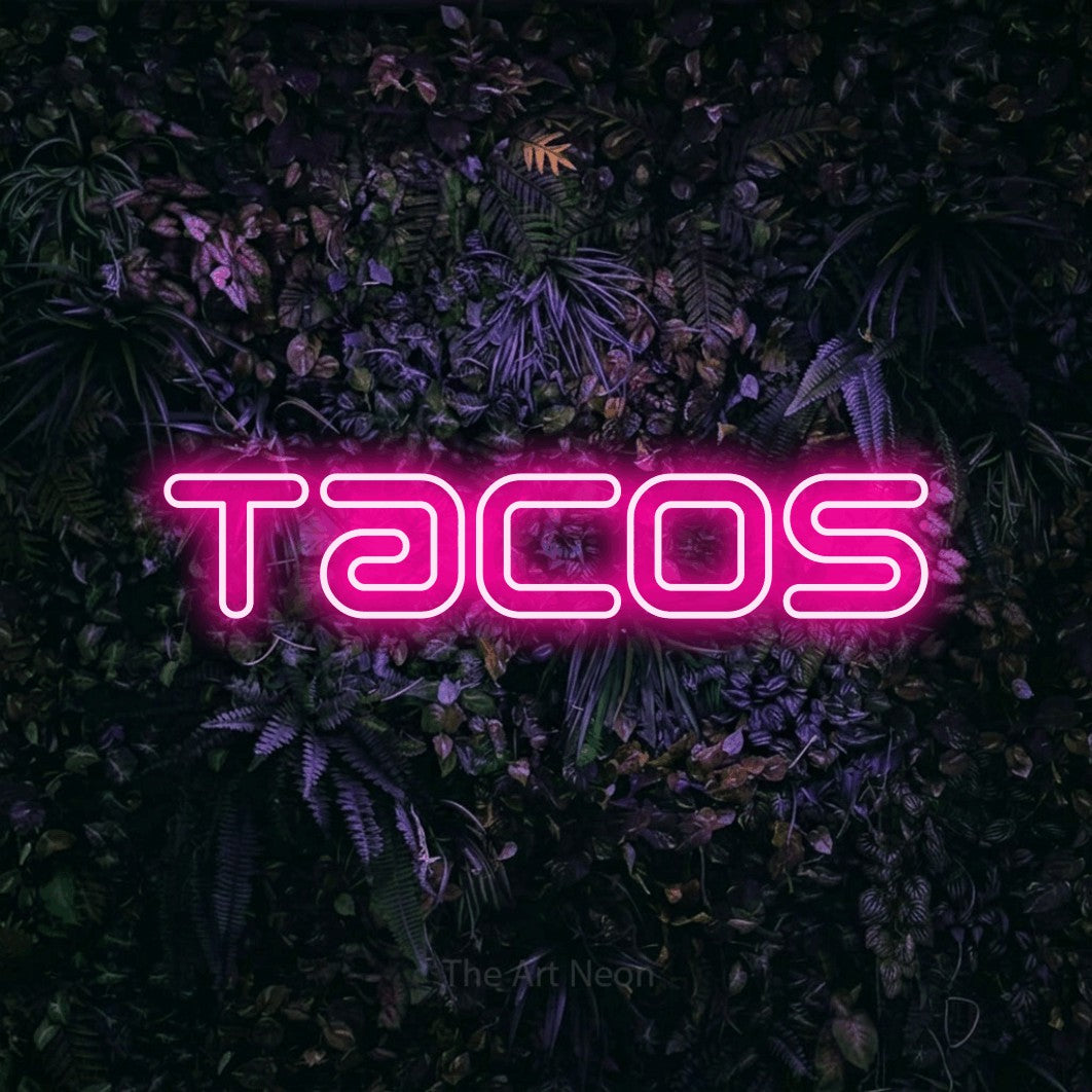 “Tacos” LED neon sign in hot pink, with futuristic double-line lettering, shown against a dark wall with purple flowers.