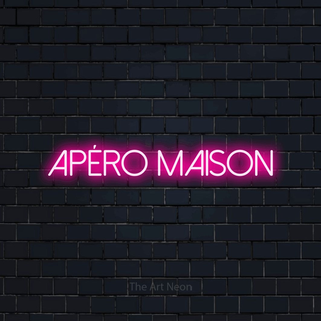 Enseigne néon LED « Apéro maison » en rose vif, en lettres fines sans empattement, présentée sur un mur de briques bleu marine foncé, pour un bar à la maison.