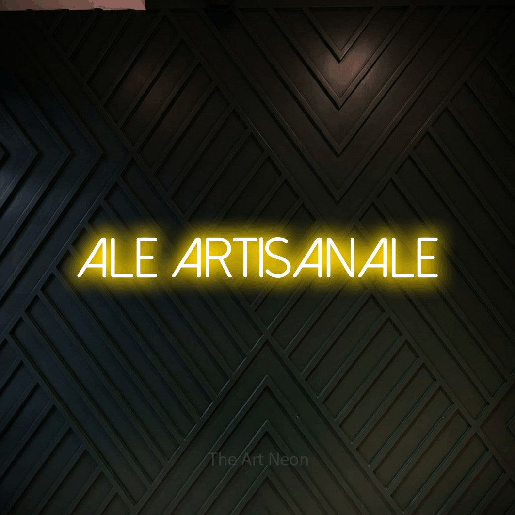 “Ale artisanale” LED neon sign in yellow, with thin sans-serif lettering, shown against a black chevron-patterned wood wall.