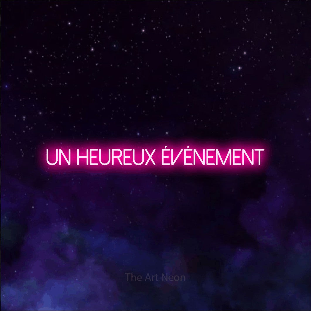 “Un heureux événement” LED neon sign in hot pink, with thin sans-serif lettering, shown against a purple galaxy backdrop.
