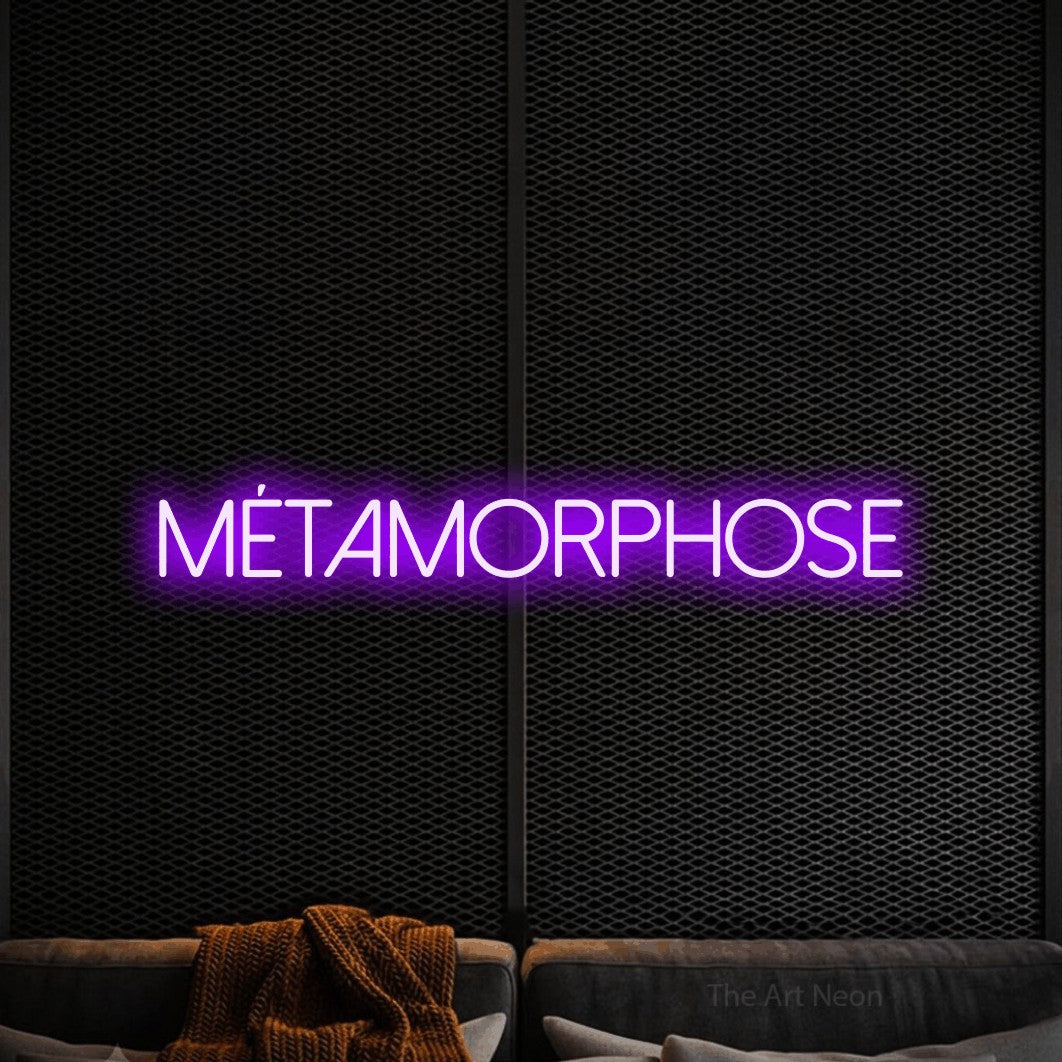 “Métamorphose” LED neon sign in purple, with thin sans-serif lettering, shown against a modern dark-toned seating area.