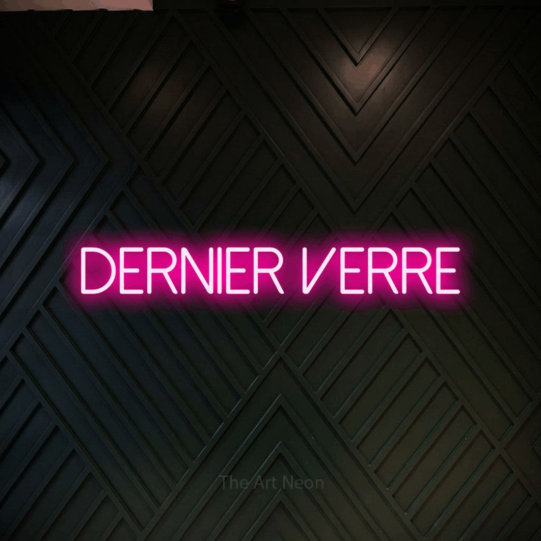 Composition en néon LED « Dernier verre » en rose vif, en lettres fines sans empattement, mise en valeur sur un mur en bois noir à motif chevron, pour un bar à la maison.
